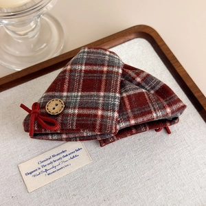 Close-up of retro plaid hair claw with vintage button and velvet bow decoration