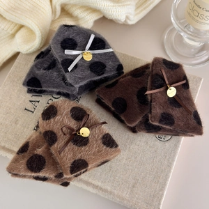 Detail of plush polka dot claw clips with silk bows and golden handmade charms