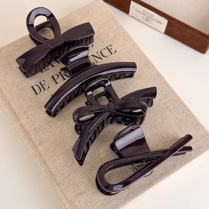 Set of four chocolate brown hair claws including bow and crescent styles with glossy finish