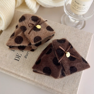 Close-up of plush polka dot hair claws with handmade metal tags and ribbon bows