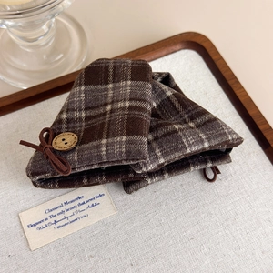 Macro shot of vintage dark brown plaid fabric hair claw with wooden button and bow detail