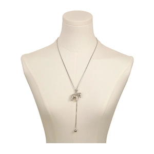 Close-up of silver Dala horse necklace with snake chain and long tassel details