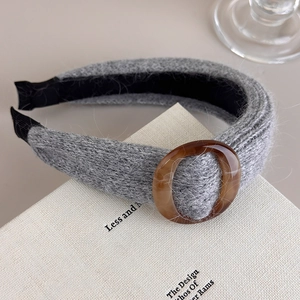 Détail d'un bandeau en maille grise avec boucle marbrée et doublure antidérapante