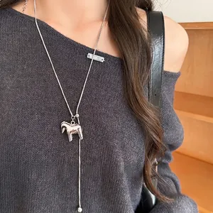 Silver Y-shaped adjustable necklace with 3D horse pendant on a grey knit sweater