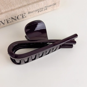 Macro view of dark chocolate brown hair claw clip with glossy finish and secure teeth