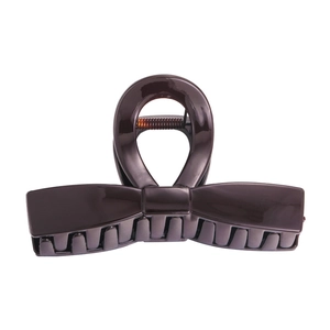 Close-up of chocolate brown bow hair claw clip showing polished texture and metal spring