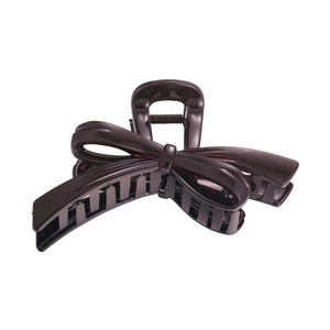 Macro detail of glossy chocolate brown bow hair claw clip with metallic spring mechanism