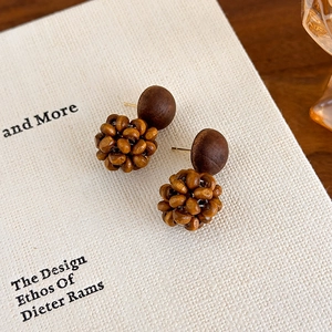 Macro detail of vintage wooden geometric earrings on a textured book surface