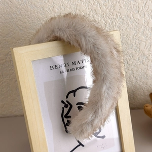 Détail du serre-tête en peluche beige sur un cadre en bois au style épuré