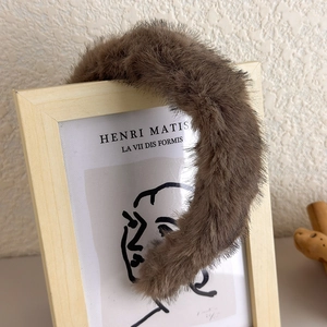 Détail d'un serre-tête en fausse fourrure marron pelucheux sur cadre en bois