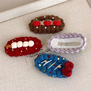 Detail of four handmade crochet fruit hair clips with pearls and metal clips