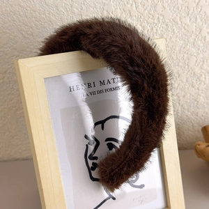 Vue détaillée du serre-tête en peluche marron foncé avec texture épaisse en fausse fourrure