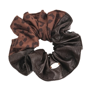 Brown leopard print and faux leather scrunchie with oval metal tag on white background