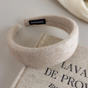 Detailansicht des Tweed-Woll-Stirnbands mit handgefertigtem Etikett auf Strick