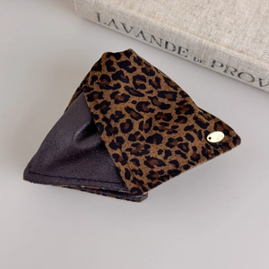 Detailed close-up of leopard print hair claw clip with brown leather and gold logo