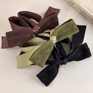 Three large knit bow banana hair clips in brown, green, and black for high ponytails
