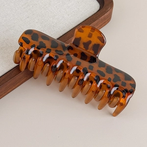 Vue détaillée d'une grande pince à cheveux motif léopard avec finition ambre et ressort robuste