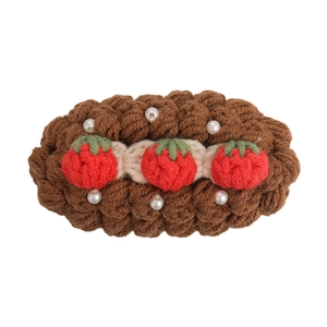 Handmade brown crochet hair clip with strawberry patterns and white pearls on white background