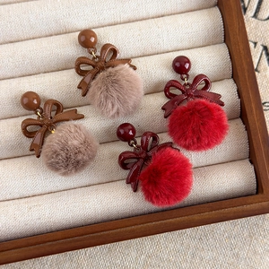 Boucles d'oreilles vintage avec nœuds et pompons en fourrure dans une boîte à bijoux