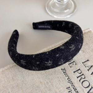 Detail of floral black knit headband with handmade label and sponge padded texture