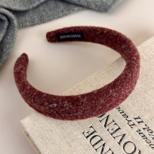 Detail of burgundy felt headband with handmade label and soft autumn fabric texture