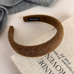 Close-up of handmade brown felt headband showing plush fiber texture and inner label