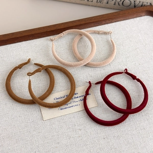 Winter flocking velvet hoop earrings in beige, tan and burgundy on a wooden tray