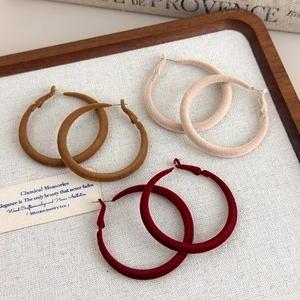 Three pairs of vintage flocking hoop earrings in beige, caramel, and burgundy velvet