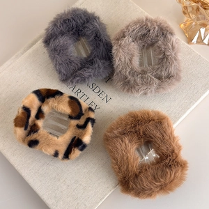 Pinces à cheveux en peluche léopard et couleurs unies sur un décor de livre doux