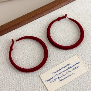 Detailed view of large burgundy velvet hoop earrings with soft flocked texture finish