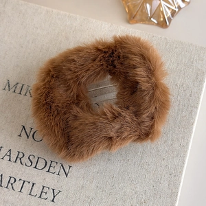 Détail d'une grande pince à cheveux en peluche marron avec fourrure douce et métal