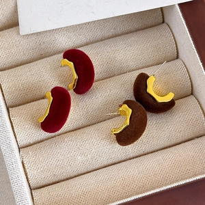 Primer plano de pendientes vintage de terciopelo en forma de C, color burdeos y marrón chocolate