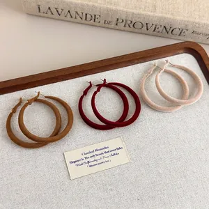 Three pairs of vintage velvet flocked hoop earrings in brown, red, and beige colors