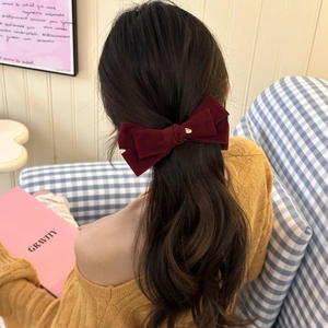 Elegant deep red velvet bow banana clip with gold detail shown on a ponytail