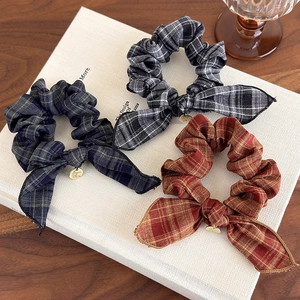 Three-piece set of plaid bow scrunchies in classic green, black, and brown patterns