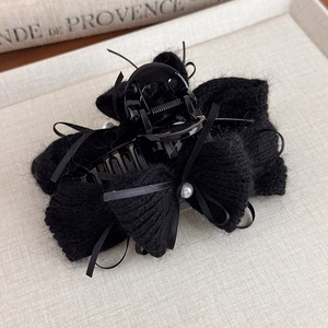 Dettaglio molletta per capelli in maglia nera con perle e nastro di seta raffinato