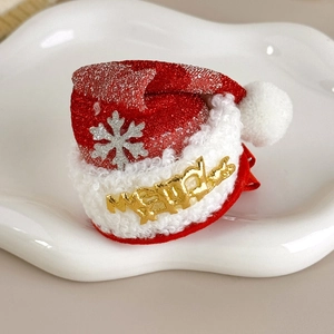 Detailed close-up of a red glitter Christmas hair clip with white fur and silver snowflake