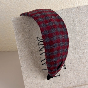 Detail of red and grey plaid headband with thick wool texture and black anti-slip end caps