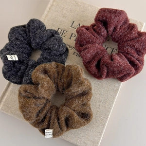 Detailed texture of autumn wool hair scrunchies in grey, brown and burgundy colors