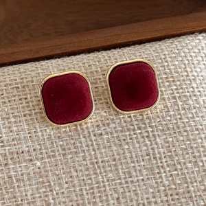Detail of vintage square velvet stud earrings in burgundy with gold metallic borders