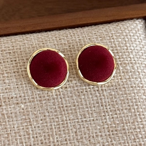 Detail of vintage square velvet stud earrings with gold metal frame on linen