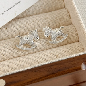 Macro detail of silver rocking horse stud earrings with pavé cubic zirconia inlay