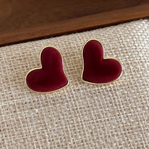 Macro shot of vintage heart-shaped earrings with burgundy velvet and gold metal trim