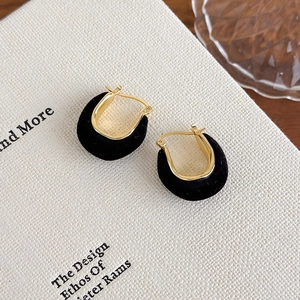 Detail of U-shaped gold-plated hoop earrings with elegant black velvet flocking