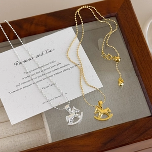 Dual rocking horse necklaces in gold and silver finish with textured hammered metal effect