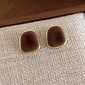 Detailed macro view of vintage square velvet stud earrings with golden metal edging