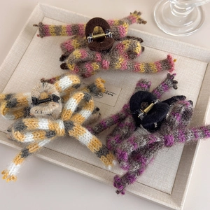 Détails de trois pinces à cheveux à nœuds tricotés aux couleurs automnales rayées