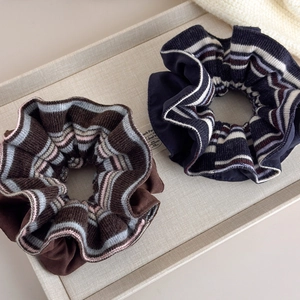 Detailed macro view of two-piece set of knitted coffee and navy striped scrunchies