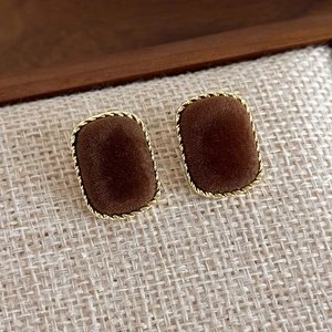 Close-up of vintage square velvet stud earrings with brown flocking and gold twist frame