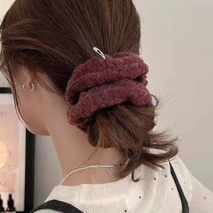 Elegant wine red wool hair scrunchie with silver clip on a model's ponytail